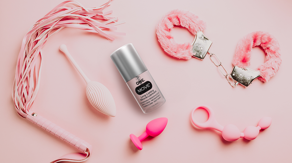 Sex toys laid flat with ONE Move on a pink background imaged