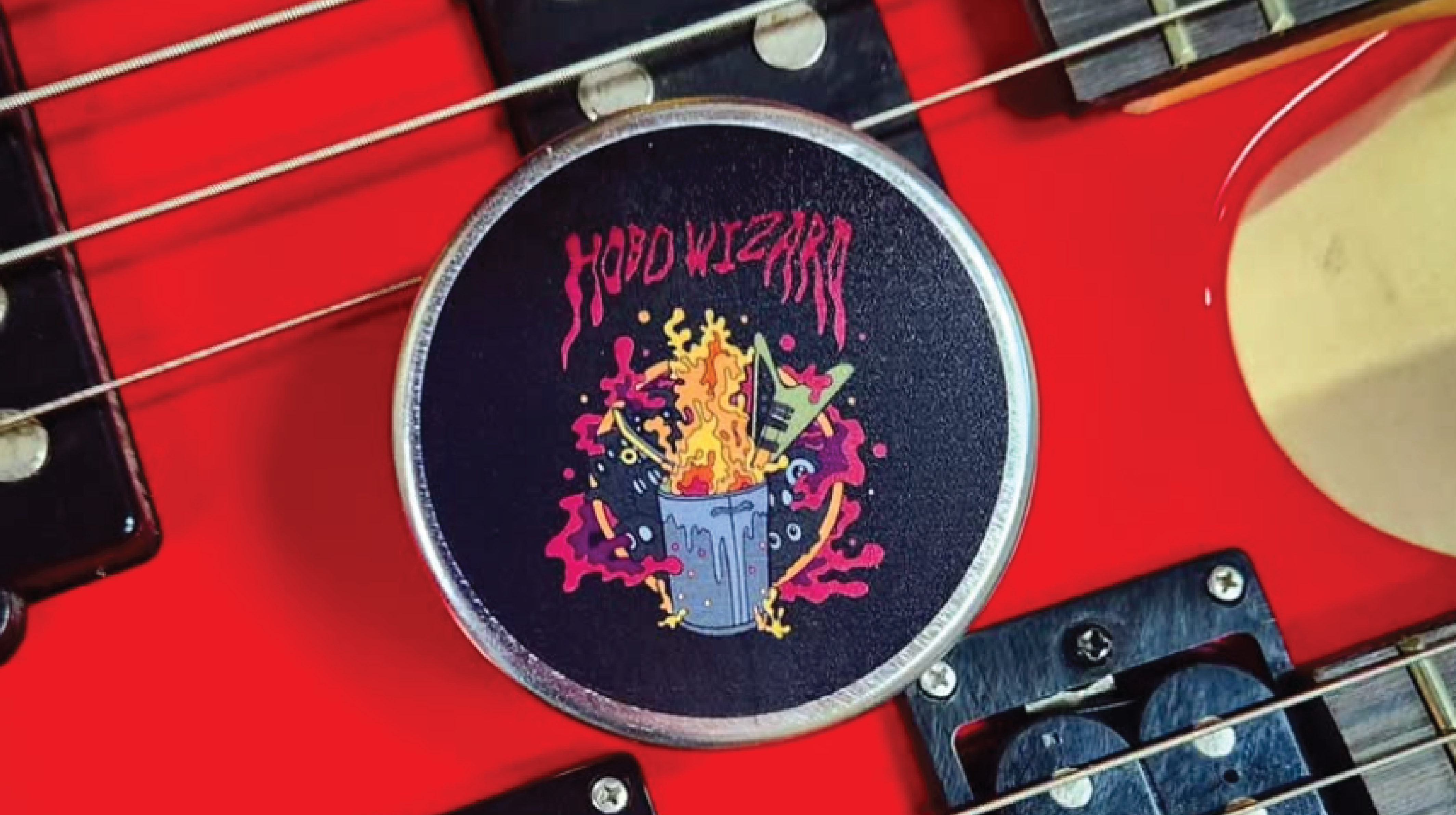 A custom printed ONE® on Stage tin for the band Hobo Wizard on top of a bright red double neck guitar.