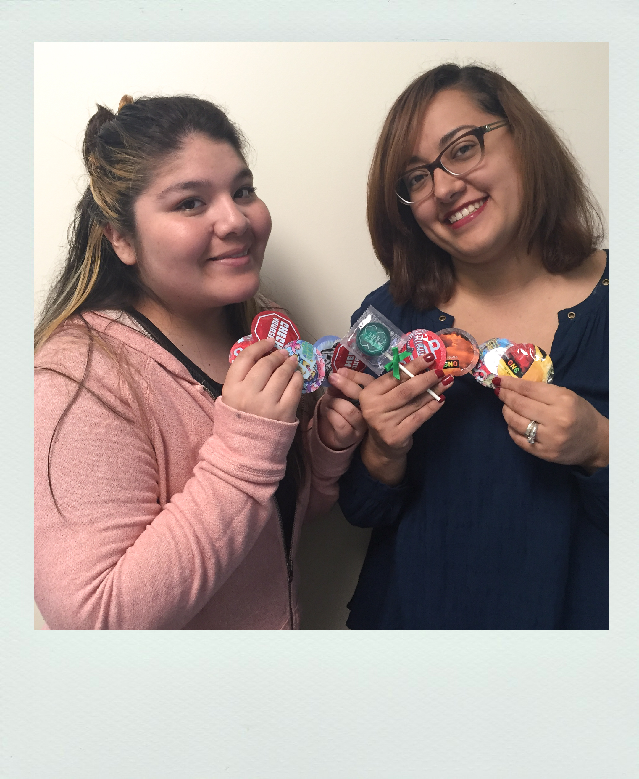 Two people posing with condoms.